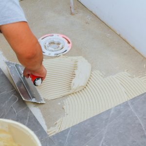 Un carreleur qui pose du carrelage